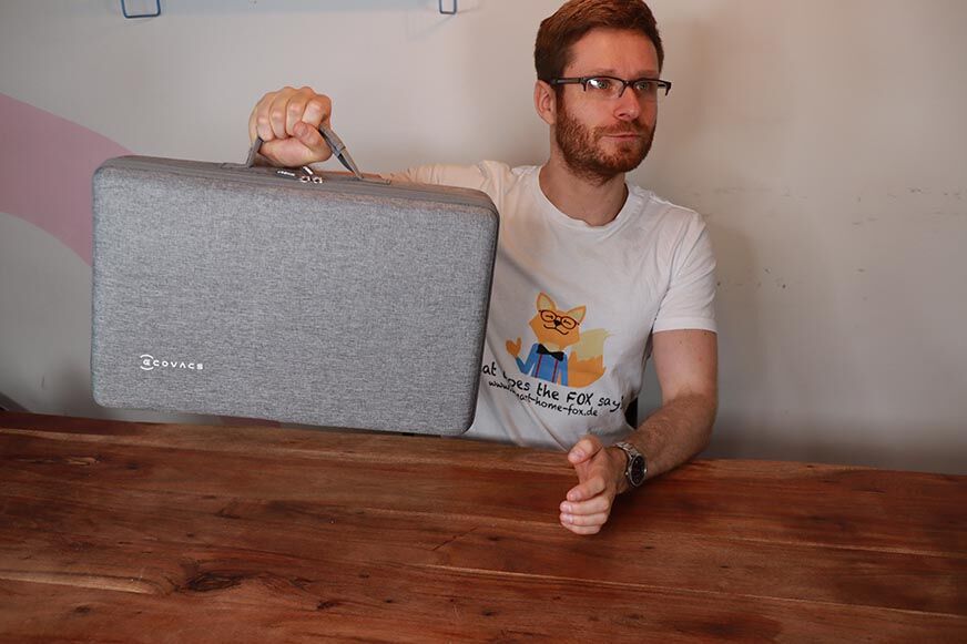 Der Koffer des Ecovacs Winbot W1 PRO wird hochgehalten.